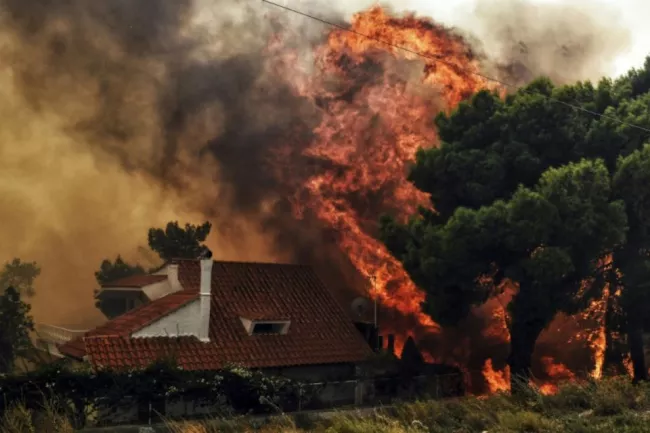 Une maison menacée par les flammes à Kineta près d'Athènes le 23 juillet 2018


