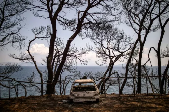 Les restes d'une voiture en bord de mer près du village de Mati, le 28 juillet 2018, quatre jours après l'incendie qui a fait au moins 91 morts. Le Premier ministre grec Alexis Tsipras a effectué lundi sa première visite sur les lieux, alimentant de nouveau les critiques de l'opposition qui a réclamé la démission des responsables de ce drame.


