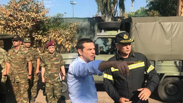 Le Premier ministre grec Alexis Tsipras (c) en déplacement sur les lieux d'un incendie meurtrier, le 30 juillet 2018 à Mati, à l'est d'Athènes


