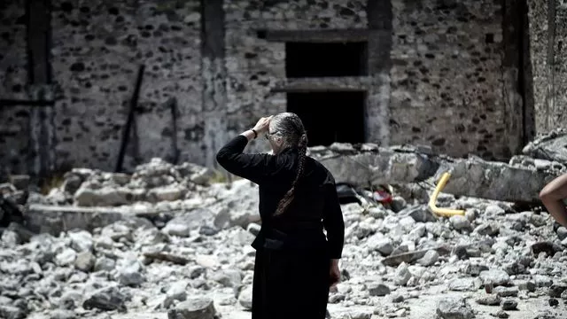 Une femme au milieu des décombres de maisons après un tremblement de terre, le 22 juillet 2017 sur l'île de Kos, en Grèce


