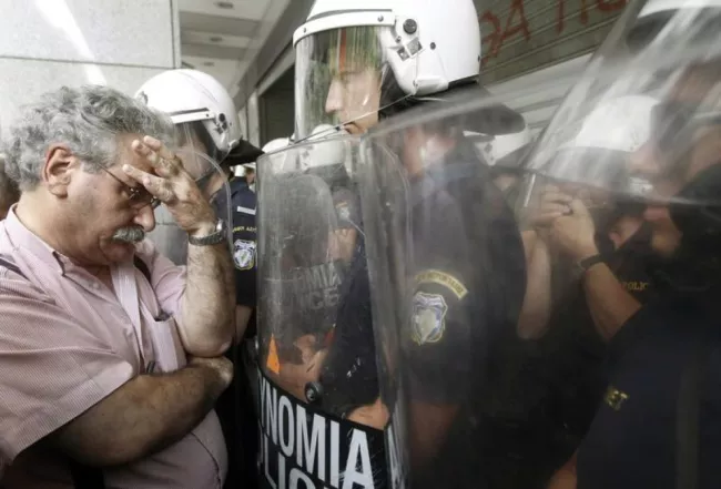 Un professeur face à la police lors d'une manifestation contre les réformes du service public, à Athènes, le 22 juillet 2013.


