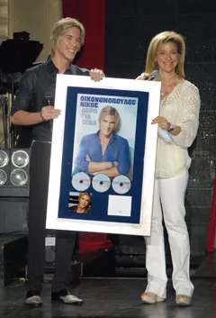 Με την διευθύνουσα σύμβουλο της ΕΜΙ, Μαργαρίτα Μάτσα, κατά τη διάρκεια της τελετής της απονομής της τριπλής πλατίνας για το «Δώρο για σένα», τον Μάϊο 2011. (φωτογραφία Μανώλης Χιώτης)